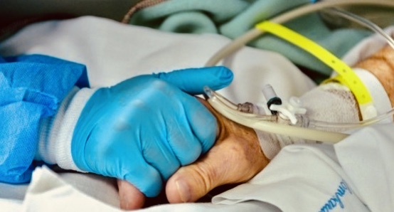 Doctor holding the hand of a patient in bed